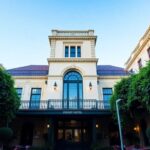 Historic Sydney hotel exterior with lush greenery and seating.