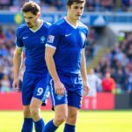 Two blue jersey players focus on the game ahead.